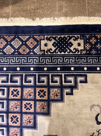 A Chinese Beijing rug with antiquities, floral design and stylized motifs, wool on cotton, 20th C.