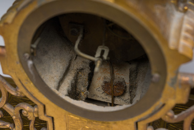 Een Franse driedelige schouwgarnituur in verguld brons bekroond met een dame met een juwelenkoffer in de hand, 19de eeuw