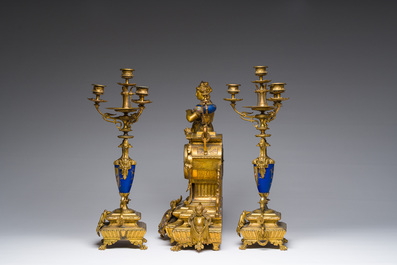 Een Franse driedelige schouwgarnituur in verguld brons bekroond met een dame met een juwelenkoffer in de hand, 19de eeuw