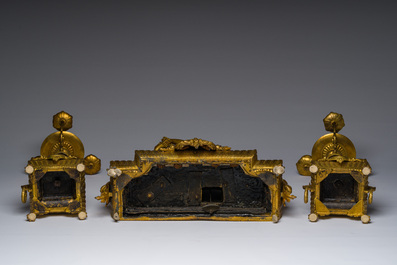 Een Franse driedelige schouwgarnituur in verguld brons bekroond met een dame met een juwelenkoffer in de hand, 19de eeuw