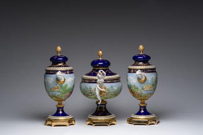 Een Italiaanse polychrome en deels vergulde driedelige S&egrave;vres-stijl schouwgarnituur met landschappen en romantische sc&egrave;nes, Giulia Mangani, 20ste eeuw