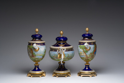 Een Italiaanse polychrome en deels vergulde driedelige S&egrave;vres-stijl schouwgarnituur met landschappen en romantische sc&egrave;nes, Giulia Mangani, 20ste eeuw