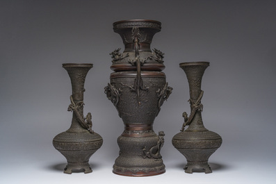 A Japanese three-piece bronze garniture with dragon relief design, Meiji, 19th C.