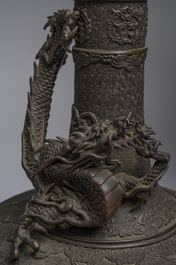 A Japanese three-piece bronze garniture with dragon relief design, Meiji, 19th C.
