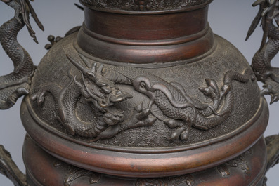 A Japanese three-piece bronze garniture with dragon relief design, Meiji, 19th C.
