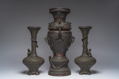 A Japanese three-piece bronze garniture with dragon relief design, Meiji, 19th C.