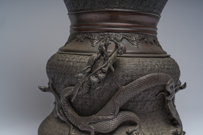 A Japanese three-piece bronze garniture with dragon relief design, Meiji, 19th C.