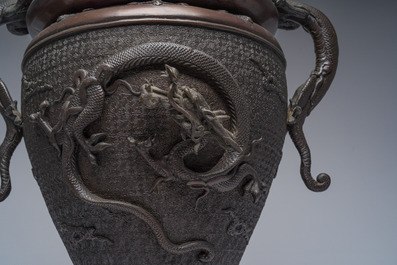 A Japanese three-piece bronze garniture with dragon relief design, Meiji, 19th C.