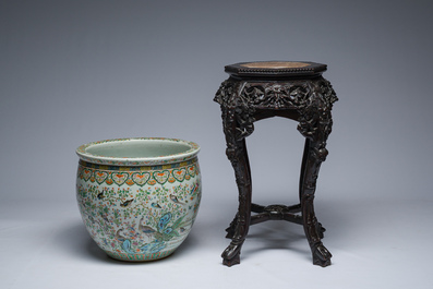 A Chinese famille rose jardini&egrave;re with birds on blossoming branches on an open worked carved wooden stand with marble top, 19th/20th C.