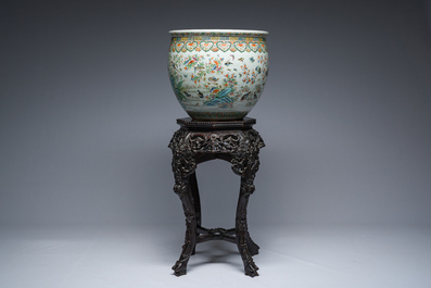 A Chinese famille rose jardini&egrave;re with birds on blossoming branches on an open worked carved wooden stand with marble top, 19th/20th C.