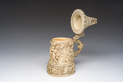 Chope couverte dite tankard en ivoire sculpt&eacute; &agrave; d&eacute;cor de sc&egrave;nes de bacchanales et de satyres en relief, Allemagne, vers 1880