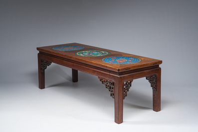 A Chinese rectangular wooden table inlaid with three round cloisonn&eacute; plaques with floral design, 20th C.