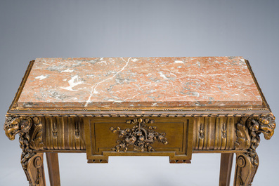 Table d'appoint de style Louis XVI en bois sculpt&eacute; et dor&eacute; &agrave; d&eacute;cor de t&ecirc;tes de bouc surmont&eacute;e d'une tablette en marbre rouge, 19&egrave;me si&egrave;cle