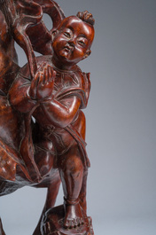 A large Chinese carved wooden figure of Guanyin with children, 20th C.