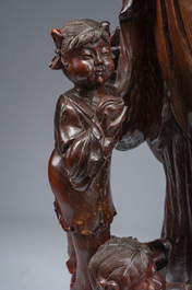 A large Chinese carved wooden figure of Guanyin with children, 20th C.
