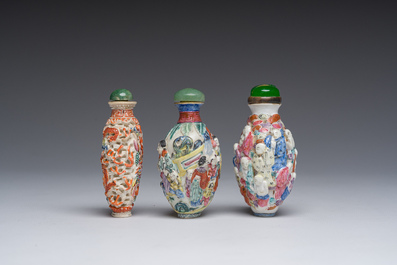 Drie Chinese famille rose snuifflessen met reli&euml;fdecor van figuren, een draak en een feniks, 19de eeuw