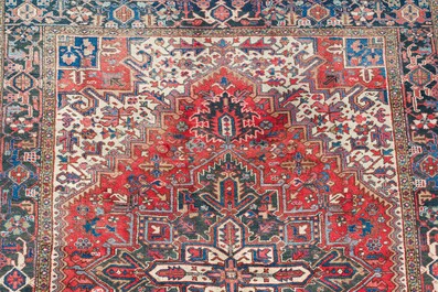 A Persian Heriz rug with floral design, wool on cotton, 20th C.