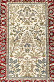 A Chinese silk Hereke style rug with birds among blossoming branches, 20th C.