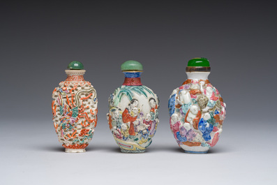 Drie Chinese famille rose snuifflessen met reli&euml;fdecor van figuren, een draak en een feniks, 19de eeuw