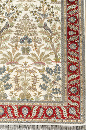 A Chinese silk Hereke style rug with birds among blossoming branches, 20th C.