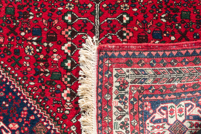 A Persian Abadeh rug with geometric floral design, wool on cotton, 20th C.