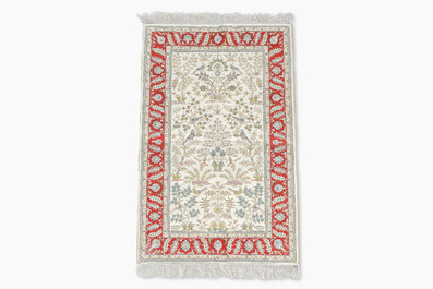 A Chinese silk Hereke style rug with birds among blossoming branches, 20th C.