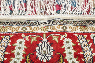 A Chinese silk Hereke style rug with birds among blossoming branches, 20th C.