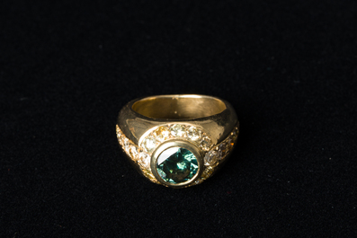 An 18 carat yellow gold men's ring with a central green-blue diamand of 1,98 carats and finished with various other diamonds, 20th C.