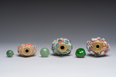 Drie Chinese famille rose snuifflessen met reli&euml;fdecor van figuren, een draak en een feniks, 19de eeuw