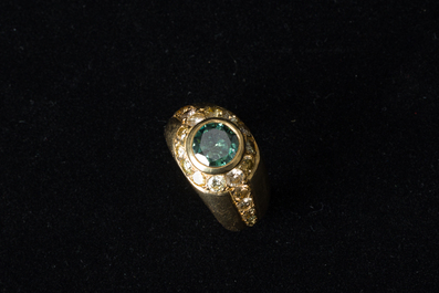 An 18 carat yellow gold men's ring with a central green-blue diamand of 1,98 carats and finished with various other diamonds, 20th C.