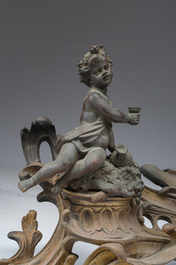 Paire de chenets en bronze partiellement dor&eacute; et patin&eacute; de style Louis XV &agrave; d&eacute;cor de putto, France, ca. 1900