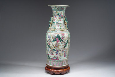 Een grote Chinese Kanton famille rose vaas met strijd- en paleissc&egrave;nes op een houten voet, 19de eeuw