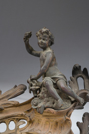 Paire de chenets en bronze partiellement dor&eacute; et patin&eacute; de style Louis XV &agrave; d&eacute;cor de putto, France, ca. 1900