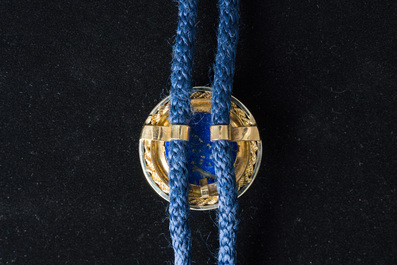 An 18 carat white and yellow gold Texan tie with a capricorn finished with diamonds (0,15 carat) and lapis lazuli, 20th C.