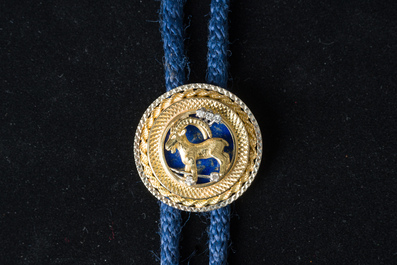 An 18 carat white and yellow gold Texan tie with a capricorn finished with diamonds (0,15 carat) and lapis lazuli, 20th C.