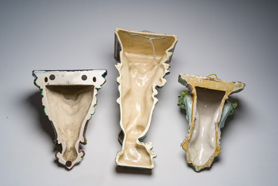 Trois consoles d'appliques en majolique polychrome &agrave; d&eacute;cor d'une sir&egrave;ne, d'un mascaron et d'un blason, une marqu&eacute;e Sarreguemines, France, d&eacute;but 20&egrave;me