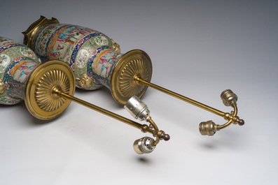 Een paar Chinese Kanton famille rose vazen met blauwe fondkleur, paleissc&egrave;nes en floraal decor omgevormd tot lampen, 19de eeuw