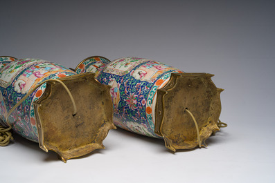 Een paar Chinese Kanton famille rose vazen met blauwe fondkleur, paleissc&egrave;nes en floraal decor omgevormd tot lampen, 19de eeuw