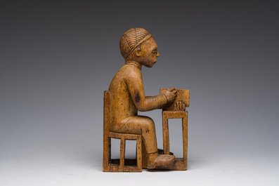 Sculpture en bois sculpt&eacute; d'un homme assis &agrave; un bureau avec un livre &agrave; la main, Bakongo, Congo, premier tiers du 20&egrave;me si&egrave;cle