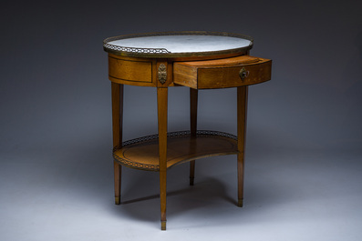 An oval French Louis XVI wooden writing table with gilt copper and brass mounts and a marble top, circa 1800