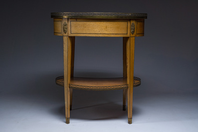 An oval French Louis XVI wooden writing table with gilt copper and brass mounts and a marble top, circa 1800