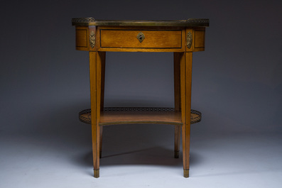An oval French Louis XVI wooden writing table with gilt copper and brass mounts and a marble top, circa 1800