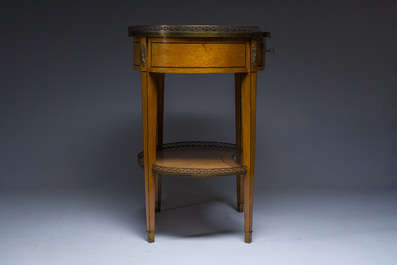 An oval French Louis XVI wooden writing table with gilt copper and brass mounts and a marble top, circa 1800