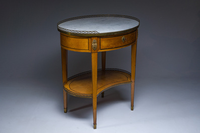 An oval French Louis XVI wooden writing table with gilt copper and brass mounts and a marble top, circa 1800