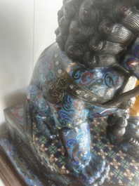 A pair of Chinese cloisonn&eacute; Buddhist lions on a wooden base, 20th C.