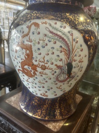 A pair of large Chinese famille rose blue-ground 'dragons and phoenixes' vases with covers, Kangxi mark, 19th C.