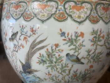 A Chinese famille rose jardini&egrave;re with birds on blossoming branches on an openworked carved wooden stand with marble top, 19th/20th C.