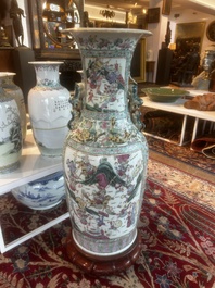 Grand vase en porcelaine de Chine famille rose &agrave; d&eacute;cor de sc&egrave;nes de bataille et de palais sur un socle en bois, 19&egrave;me si&egrave;cle