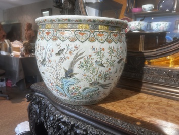 A Chinese famille rose jardini&egrave;re with birds on blossoming branches on an openworked carved wooden stand with marble top, 19th/20th C.