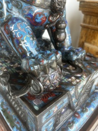A pair of Chinese cloisonn&eacute; Buddhist lions on a wooden base, 20th C.